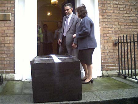 Greek diplomats looking at coffin