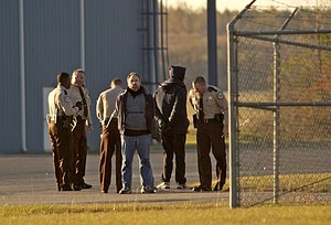 Bill Ramsey, center, of St. Louis was one of 14 people arrested this morning at the Johnston County Airport after they gathered to protest the use of the airport by a company that reportedly shuttles prisoners for the CIA.