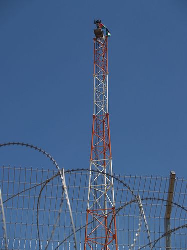 Tito on the top of military tower hanging Palestinian flag