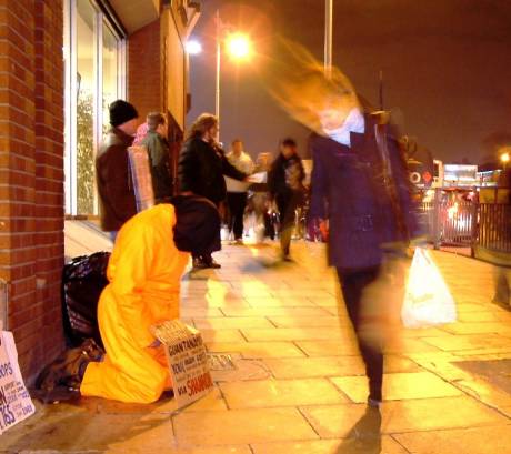 Christmas Shopper passes by Guantanamo Man