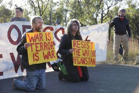 Veteran members of the Catholic Worker movement Jim Dowling and Ciaron O'Reilly blockade military vehicles by kneeling in Nonviolent Resistance to the Talisman Sabre War Games Exercise