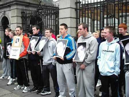 Terence's friends holding up pictures of him.