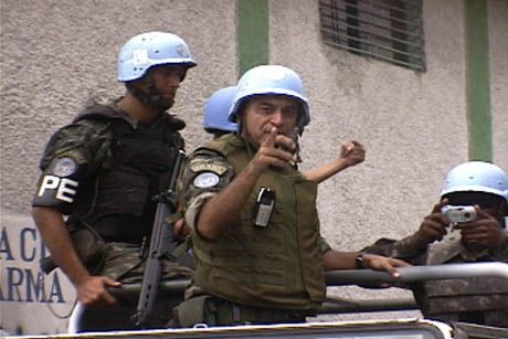 Brazilian officer who refused to identify himself instructs a Haitian camerman to photograph journalist Kevin Pina.