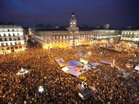 About 20,000 young people angry over high unemployment have spent the night camping in a famous square in Madrid as political protest grows.